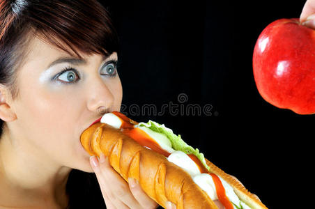 美丽饥饿的女孩吃三明治的画像