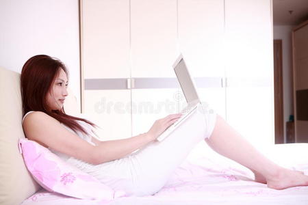 女人在床上用笔记本电脑