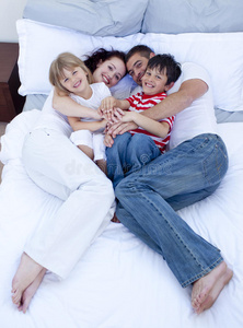 父母和孩子在床上放松的高视角
