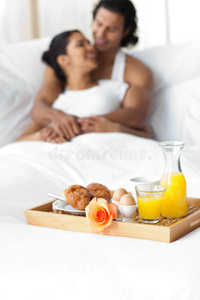 微笑的情侣在床上吃早餐
