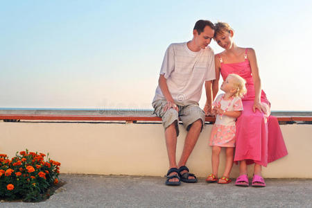 幸福的一家人坐在度假村的长椅上