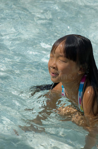 在游泳池游泳的亚洲女孩