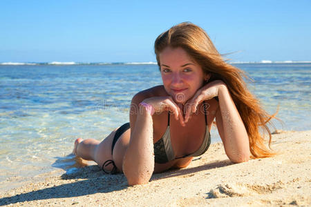 穿比基尼在度假海滩日光浴的女孩