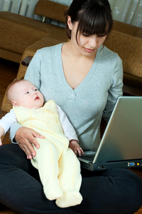 母亲婴儿和笔记本电脑