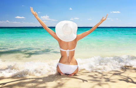 坐在沙滩上的妇女，双臂高举