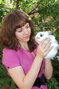 带着白色毛茸茸的兔子的女孩图片