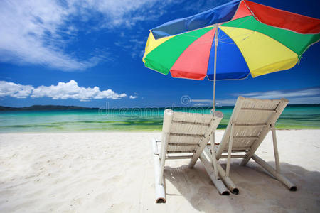 两把沙滩椅和五颜六色的伞