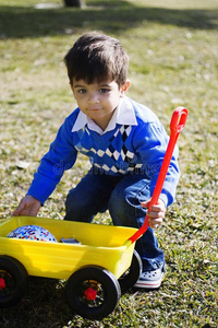 快乐的西班牙裔男孩玩他的玩具卡车