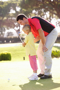 父亲教女儿打高尔夫球
