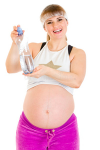 微笑的孕妇拿着一瓶水