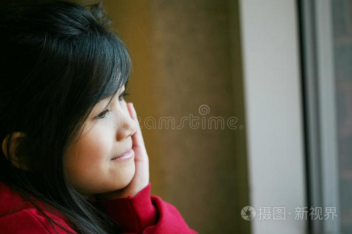 亚洲小女孩静静地坐在窗边
