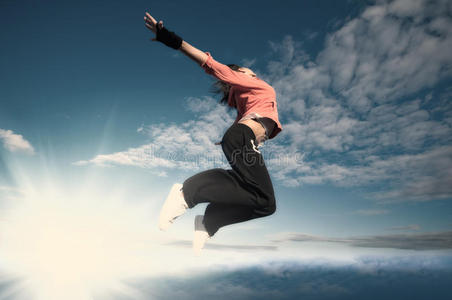 女运动员在天空和太阳上跳跃和飞翔