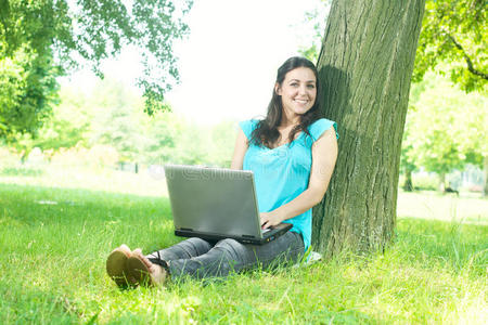 快乐的年轻女子在户外使用笔记本电脑