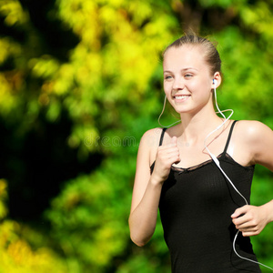 在绿色公园跑步的年轻女子