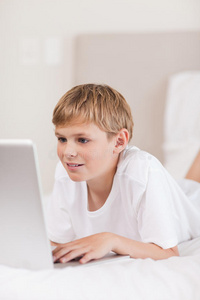 一个可爱的男孩用笔记本电脑的画像
