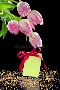 美丽的郁金香和带蝴蝶结的空白礼品标签