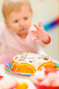 特写生日蛋糕和吃涂抹的婴儿