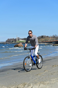 在海边骑自行车的男人