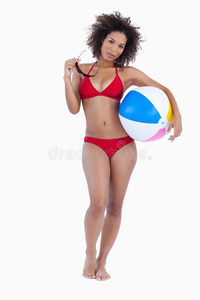 迷人的女人拿着太阳镜和沙滩球图片