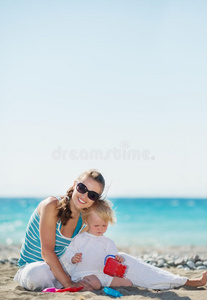 快乐的妈妈和宝宝在沙滩上玩耍