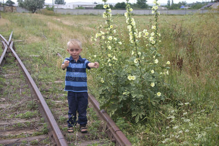 可爱的金发小男孩在铁路上玩耍