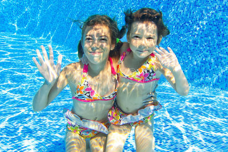 游泳池里快乐微笑的水下儿童图片
