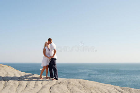 年轻夫妇站在岩石上接吻