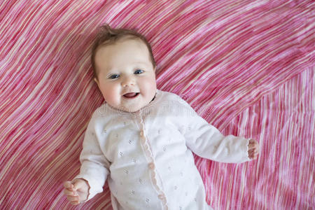 粉红色床单上的婴儿图片