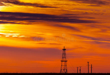废弃的石油钻塔电线和日落