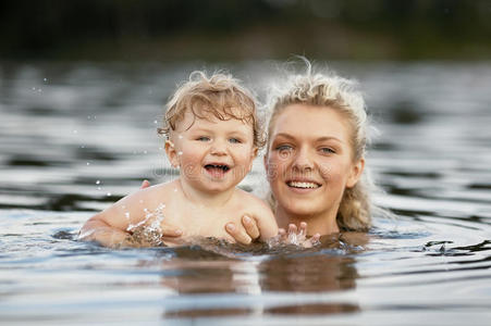 美丽的年轻母亲和儿子在水里