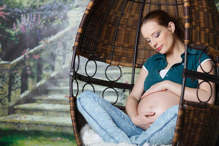孕妇坐在秋千上。