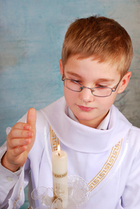 男孩拿着蜡烛去参加第一次圣餐会