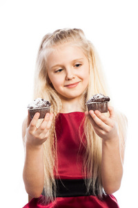 在两个蛋糕中作选择的女孩图片