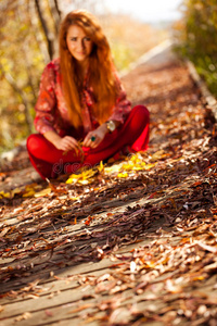 女人坐在秋天的自然失去焦点