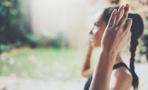 女性的手的特写视图。练瑜伽室内华丽的年轻女子。美丽的女孩在实践课中微笑。平静和放松，幸福的概念。横向的 模糊的背景