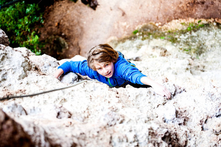 男孩爬上岩石