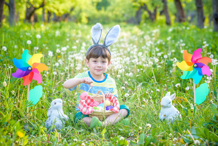 在复活节寻找复活节彩蛋在春天的花园里的小男孩