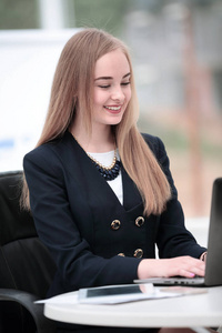 幸福微笑的业务女人在现代办公笔记本电脑上工作
