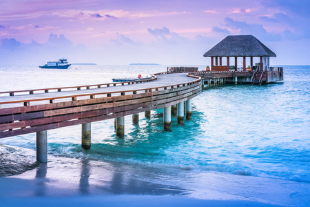 日落背景下马尔代夫的木码头和蓝海