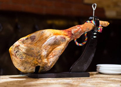 Jamon。三教九流。传统的西班牙火腿，黑色关闭。切片 Hamon 黑毛猪，整个 jamon 的木架子，帕尔玛火腿切片上。Ham