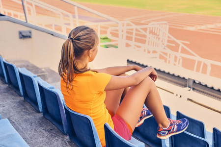运动的女性坐在体育场座位上