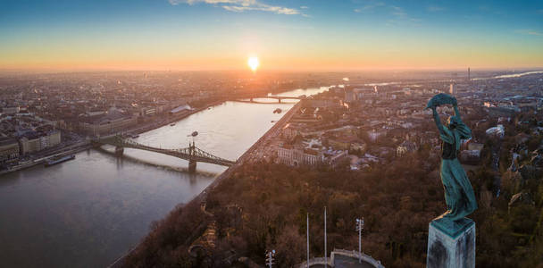 布达佩斯, 匈牙利空中全景日出观在自由女神像与自由桥和多瑙河在从盖勒特山拍摄的背景