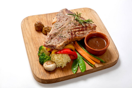 烧烤食物烧烤牛肉牛排配热酱和蔬菜在木板上