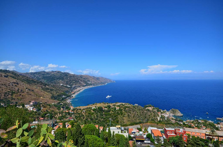 陶尔米纳, 意大利, 西西里岛2015年8月26日。灿烂的全景从希腊剧院, 朝海。郁郁葱葱的自然, 地中海的植被, 花朵。海和小
