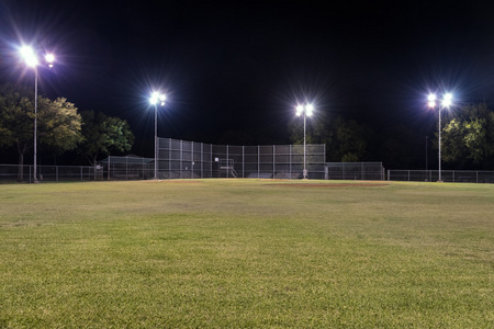 在晚上亮着灯的空棒球场