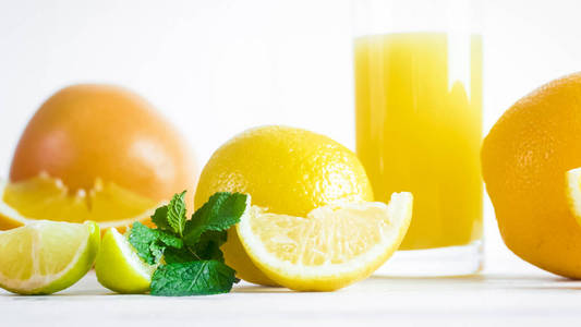 白色背景下鲜橙汁玻璃的柠檬和桔子特写图像