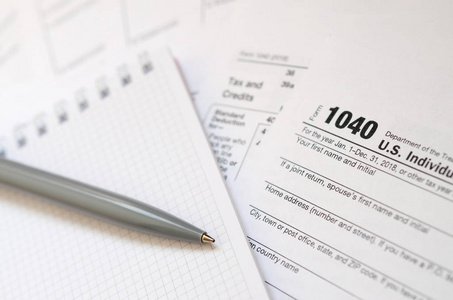 笔和笔记本是位于税表1040美国个人所得税的回报。纳税时间