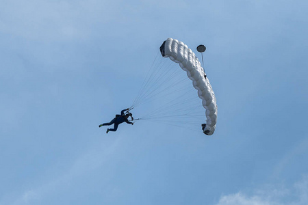 伞兵白色降落伞对抗清澈的蓝天