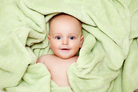 白种人男婴覆盖着绿色的快乐毛巾 c 在笑