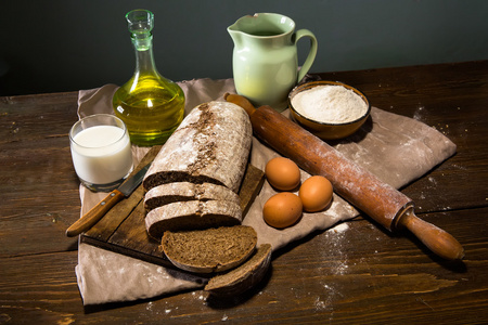 面包和面粉，牛奶和鸡蛋在窝的静物照片